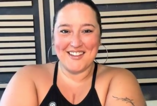 Kyla Hallums, a woman in a black top with large hoop earrings. Her hair is in a ponytail.